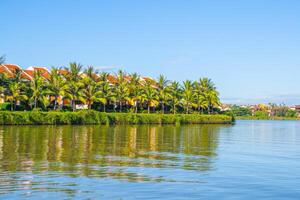 landscape of life and houses next to Thu Bon river in Hoi An ancient town, Quang Nam Province, Vietnam. Hoi An is one of the most popular destinations in Vietnam. photo