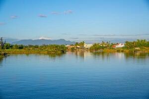 landscape of life and houses next to Thu Bon river in Hoi An ancient town, Quang Nam Province, Vietnam. Hoi An is one of the most popular destinations in Vietnam. photo