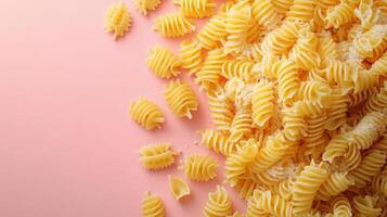 Close-Up of Uncooked Rotini Pasta on a Pink Background with Copy Space photo