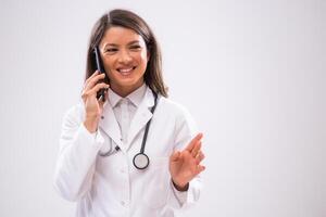 Portrait of happy doctor who is talking on phone with patient. photo