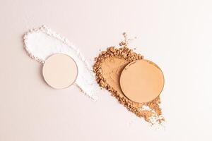 Samples of compact powder and loose powder of different tones, strokes, blocks on a white background. top view. texture of various powders. layout. photo