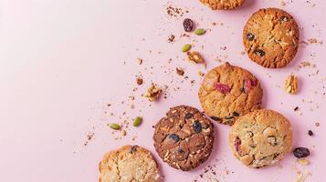 Assortment of Cookies with Nuts and Dried Fruit on Pink Background photo