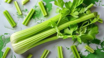 Fresh Green Celery Stalks and Leaves on a Green and White Background with Sliced Pieces photo