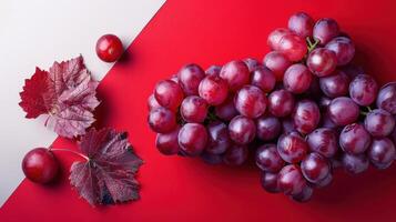 Fresh Red Grapes with Leaves on a Red and White Background - High-Quality Stock Photo for Food and Beverage Use