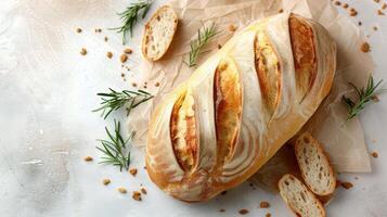 Freshly Baked Artisan Bread Loaf on Parchment Paper with Rosemary Garnish on Light Background photo