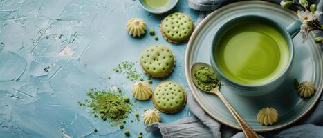 Elegant Matcha Tea and Cookies Arrangement on Textured Blue Background with Blossoms photo