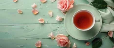 Elegant Tea Cup with Rose Petals on Mint Green Wooden Table - Serene and Romantic Setting photo