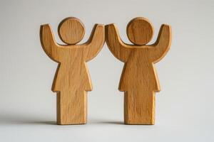 Wooden Figures of People with Raised Arms on Neutral Background photo