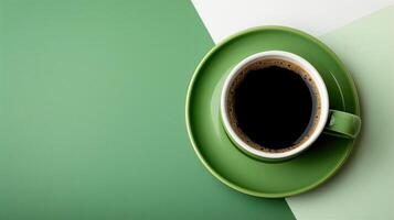 Overhead View of a Cup of Black Coffee in a Green Cup and Saucer on a Modern Green and White Background photo