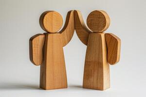 Wooden Figures High-Fiving Symbolizing Teamwork, Unity, and Collaboration on a Neutral Background photo