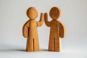 Wooden Figures High-Fiving - Symbol of Teamwork, Unity, and Collaboration in Minimalist Style photo