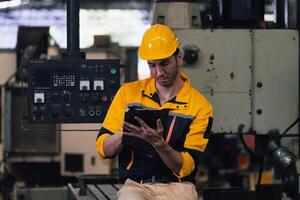Caucasian engineer using a laptop in a factory. man working in plastics factory. photo