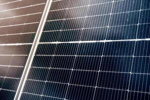 texture of cell of modern black solar panel at sunset in close-up. Renewable green energy photo