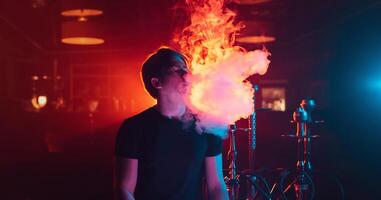 man is relaxing and Smoking a hookah and blowing a cloud of smoke in a lounge cafe photo
