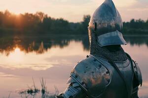 Medieval Knight in Armor Contemplating Serene Sunset by a Lake photo