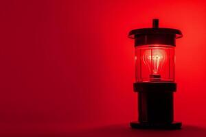Vintage Lantern with Red LED Light on a Red Background photo