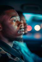 Pensive Young Man Riding in Car at Night with Colorful Bokeh Background photo