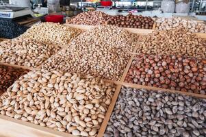 assortment of different nuts on the counter at oriental bazaar. Almonds, pistachios, hazelnuts, macadamia, pecans and cashews photo