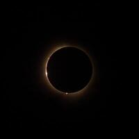 HD image of the solar eclipse in 2024 with the moon finally covering the sun. Baily's beads of light seen through canyons on the moon photo