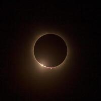 HD images of the solar eclipse in 2024 with the moon finally covering the sun. Baily's beads of light seen through canyons on the moon surface photo