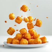 Delicious crispy fried tater tots spraying out from the plate. photo