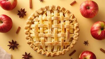 A slice of delicious freshly baked apple pie with an assortment of apples around it and cinnamon sti photo