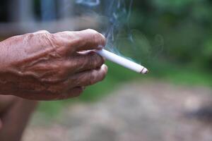 Close up unhealthy hand holds homemade cigarette for smoking. Concept, smoking is bad for health. Private favorite for relaxation but can cause health problems and bad smell. photo