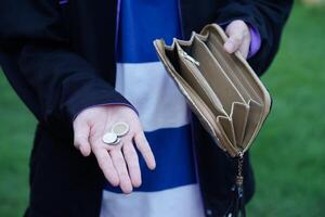 Close up hands holding empty wallet and shows Thai coins money. Concept, poor, bad economic crisis. Financial problems. Broke or less money at the end of month. photo
