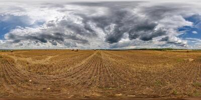 spherical 360 hdri panorama on rye and wheat fields with hay bales with rain storm clouds in dark sky in equirectangular seamless projection, as skydome replacement in drone panoramas photo