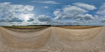 hdri 360 panorama on gravel road among fields in spring nasty day with awesome clouds in equirectangular full seamless spherical projection, for VR AR virtual reality content photo