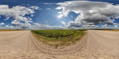 hdri 360 panorama of blue sky with awesome clouds on roadside of gravel road among fields in equirectangular full seamless spherical projection, for VR AR content or skydome replacement photo