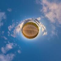 simple little tiny planet without buildings in blue sky with beautiful clouds. Transformation of spherical panorama 360 degrees. Spherical abstract aerial view. Curvature of space. photo