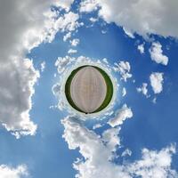simple little tiny planet without buildings in blue sky with beautiful clouds. Transformation of spherical panorama 360 degrees. Spherical abstract aerial view. Curvature of space. photo