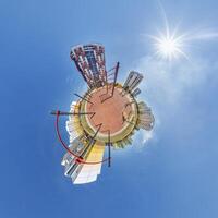 abstract swirling tiny planet spherical panorama of multi-storey buildings of skyscrapers of a residential complex in the form of a butterfly, bugs, crabs in blue sky photo