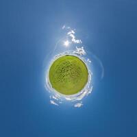 simple little tiny planet without buildings in blue sky with beautiful clouds. Transformation of spherical panorama 360 degrees. Spherical abstract aerial view. Curvature of space. photo