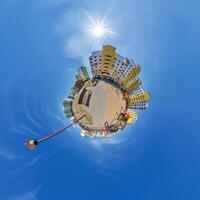 abstract swirling tiny planet spherical panorama of multi-storey buildings of skyscrapers of a residential complex in the form of a butterfly, bugs, crabs in blue sky photo