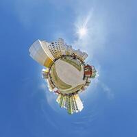 abstract swirling tiny planet spherical panorama of multi-storey buildings of skyscrapers of a residential complex in the form of a butterfly, bugs, crabs in blue sky photo