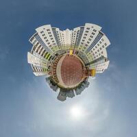 abstract swirling tiny planet spherical panorama of multi-storey buildings of skyscrapers of a residential complex in the form of a butterfly, bugs, crabs in blue sky photo