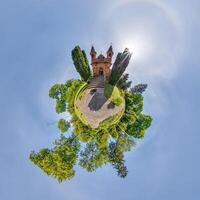 little planet transformation of spherical panorama 360 degrees overlooking church in center of globe in blue sky. Spherical abstract aerial view with curvature of space. photo