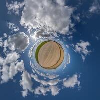 simple little tiny planet without buildings in blue sky with beautiful clouds. Transformation of spherical panorama 360 degrees. Spherical abstract aerial view. Curvature of space. photo