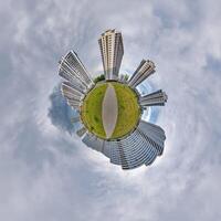 abstract swirling tiny planet spherical panorama of multi-storey buildings of skyscrapers of a residential complex in the form of a butterfly, bugs, crabs in blue sky photo