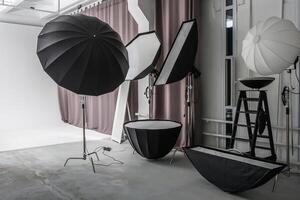 interior of bright space of photo studio with large white cyclorama with lighting equipment
