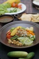 Close up of gado-gado ingredients in a plate, various vegetables and fried tempeh photo