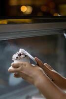Close up hand of a person scooping ice cream in to a paper bowl with blurred background photo