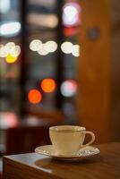 Cup of coffee on the table with bokeh blur background photo