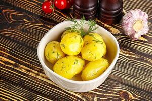 Boiled potato with oil and dill photo