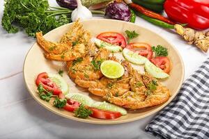Grilled prawn served lime and vegetables photo