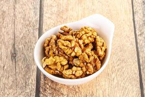 Cracked unshelled walnut in the bowl photo
