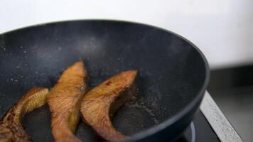 Fry salmon in a frying pan Salmon steak is placed on a frying pan and fried. Slow motion of cooking diet fish in the kitchen at home. High quality 4k footage video