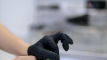 Wear black latex gloves slow-motion closeup shot on male hands wearing black latex gloves against blurred background video